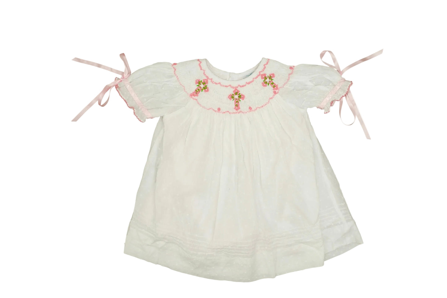 White baby dress with floral embroidery and pink ribbons on a white background