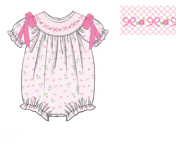 The Belle Fleur hand-smocked bubble romper with floral detailing and soft cotton fabric. Perfect for birthdays, portraits, holidays, and everyday wear.