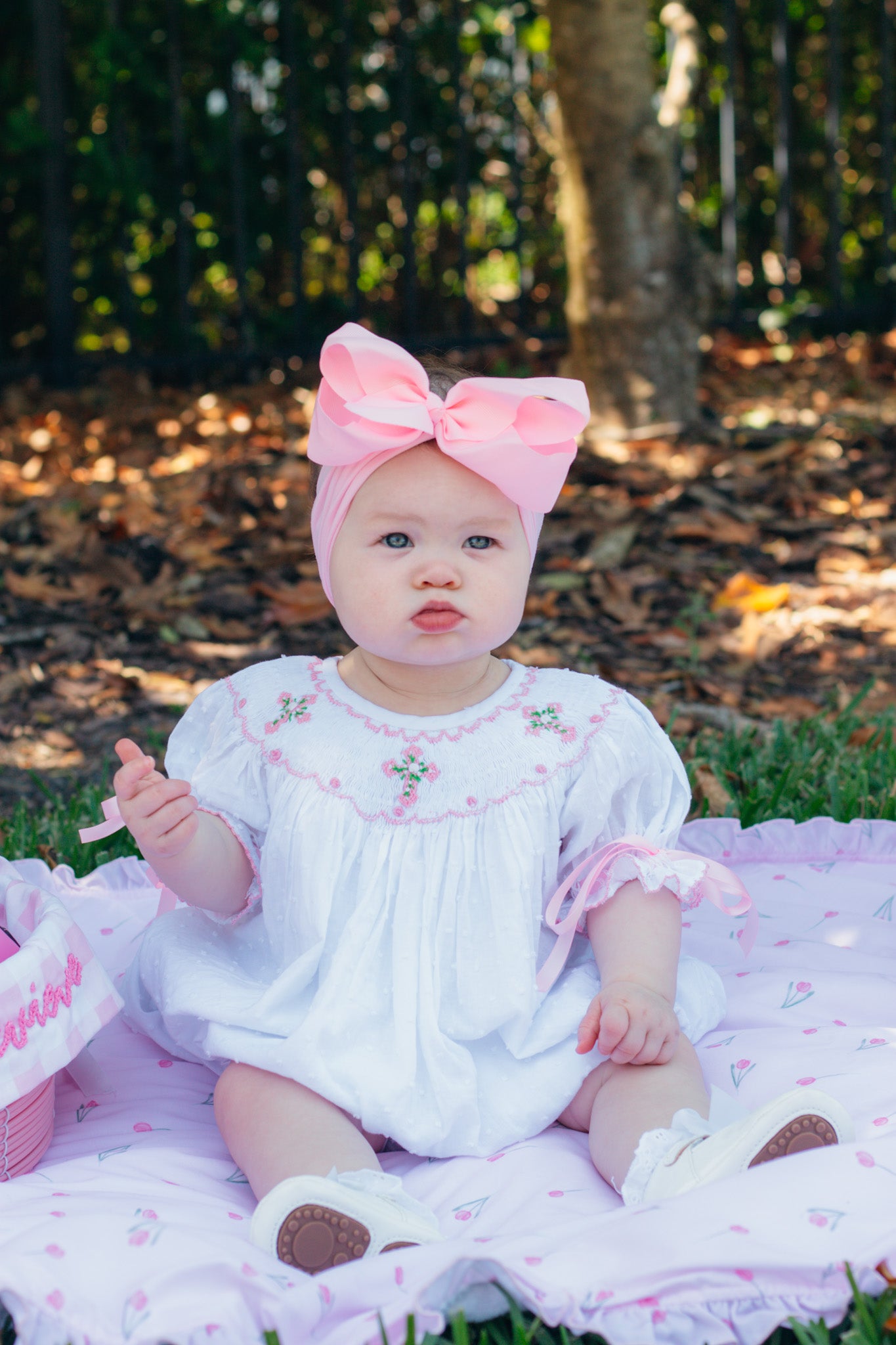 White hand-smocked outfit with crosses and roses, heirloom details for baptisms and special occasions.