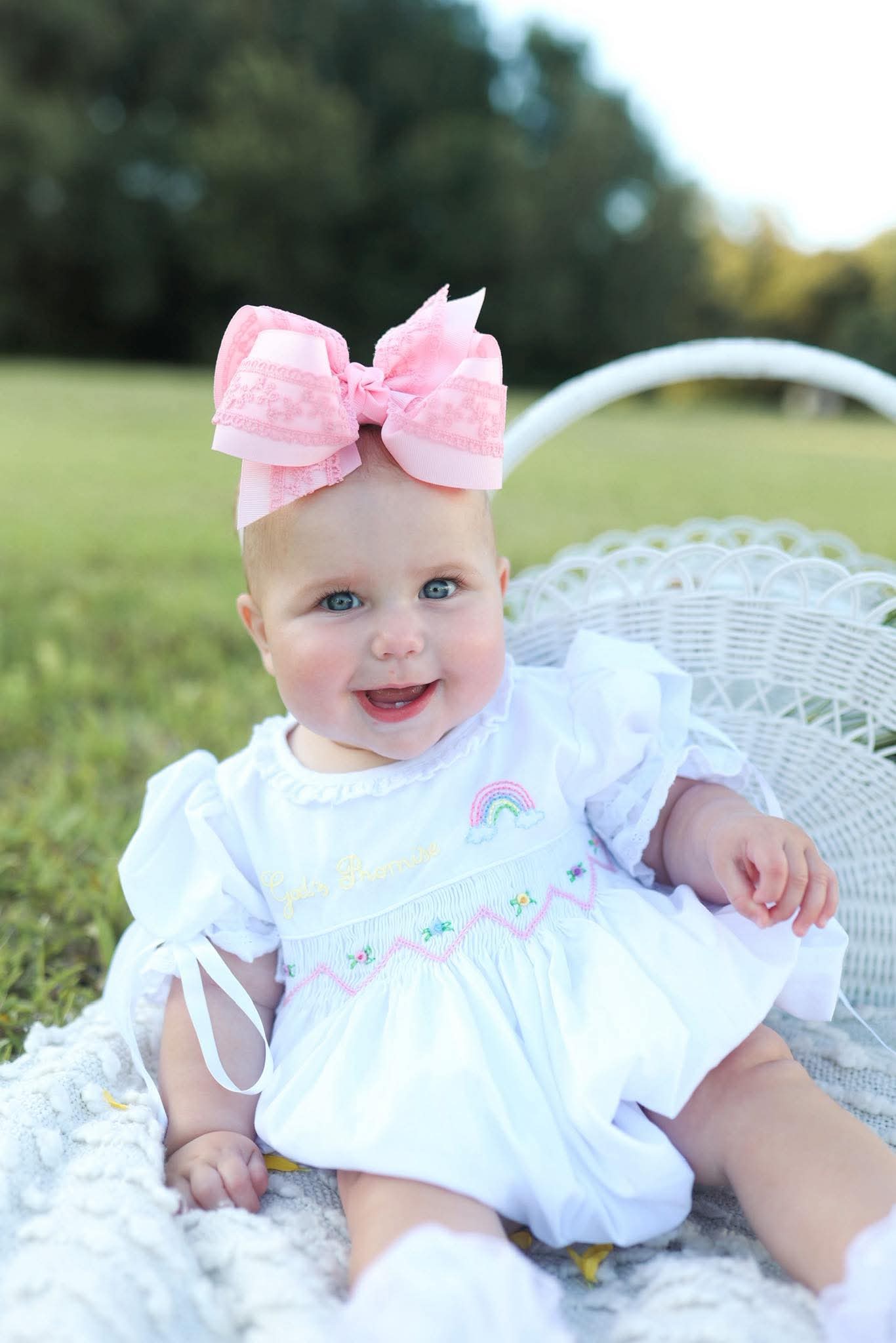 Hand-smocked girls dress with classic detailing in soft pastel colors