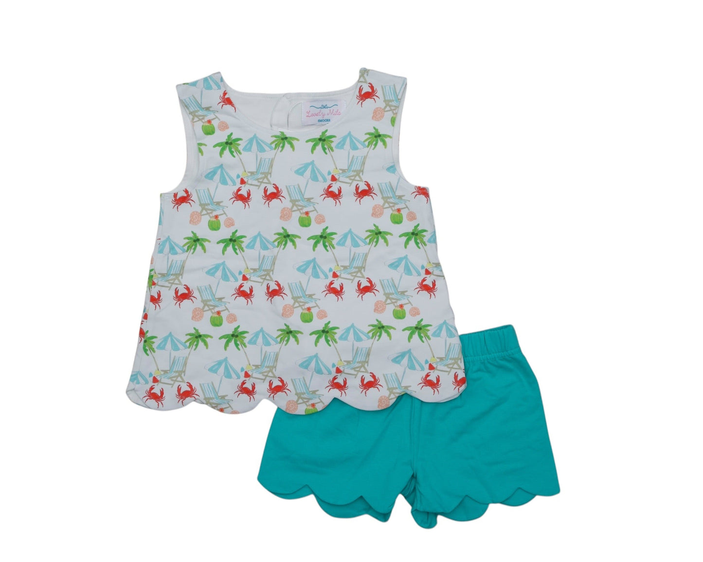 Children's outfit with patterned top and teal shorts on a white background