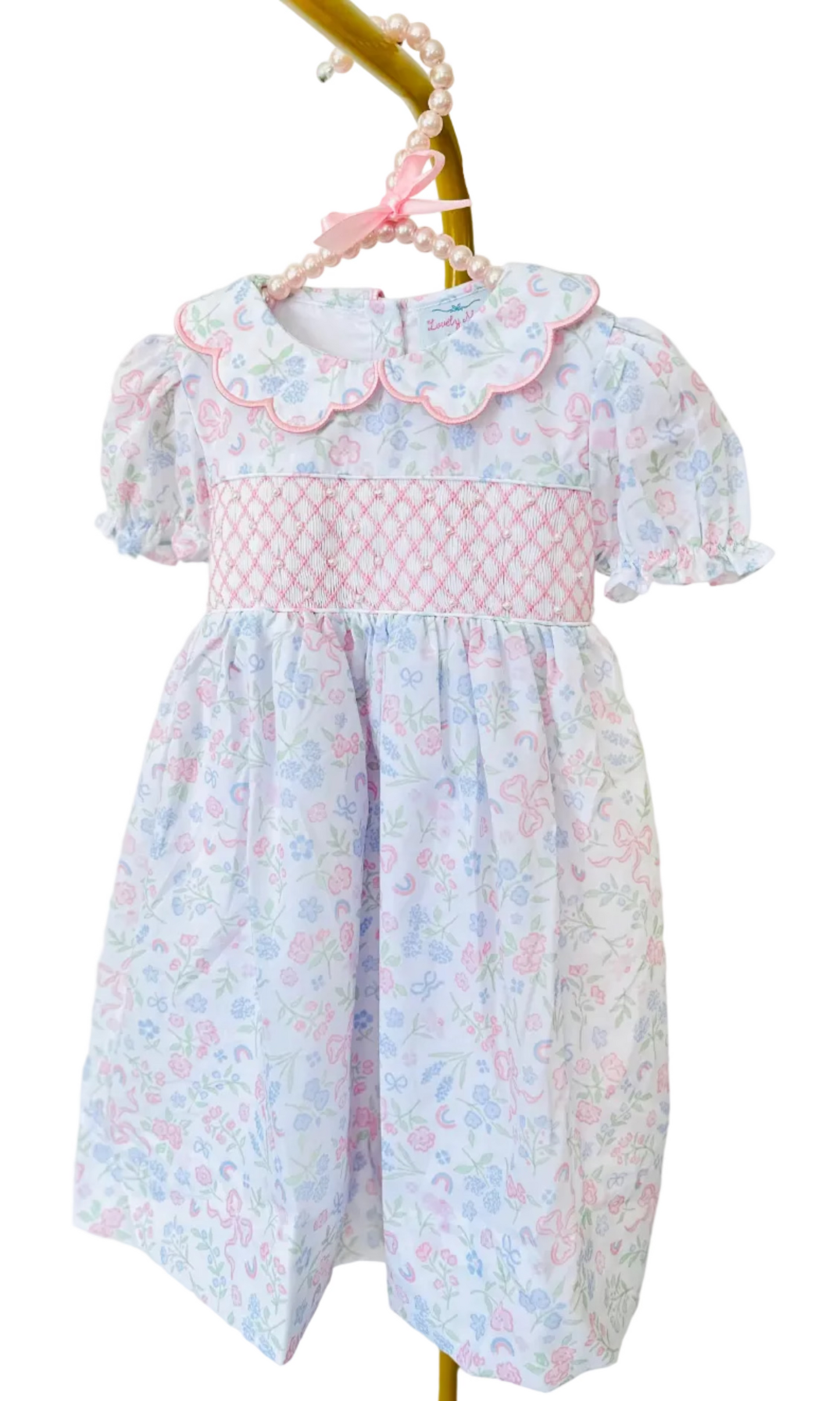 Hand-smocked girls’ dress in 100% cotton with print floral with bows. Classic, timeless, and coordinated with Mom Dress.