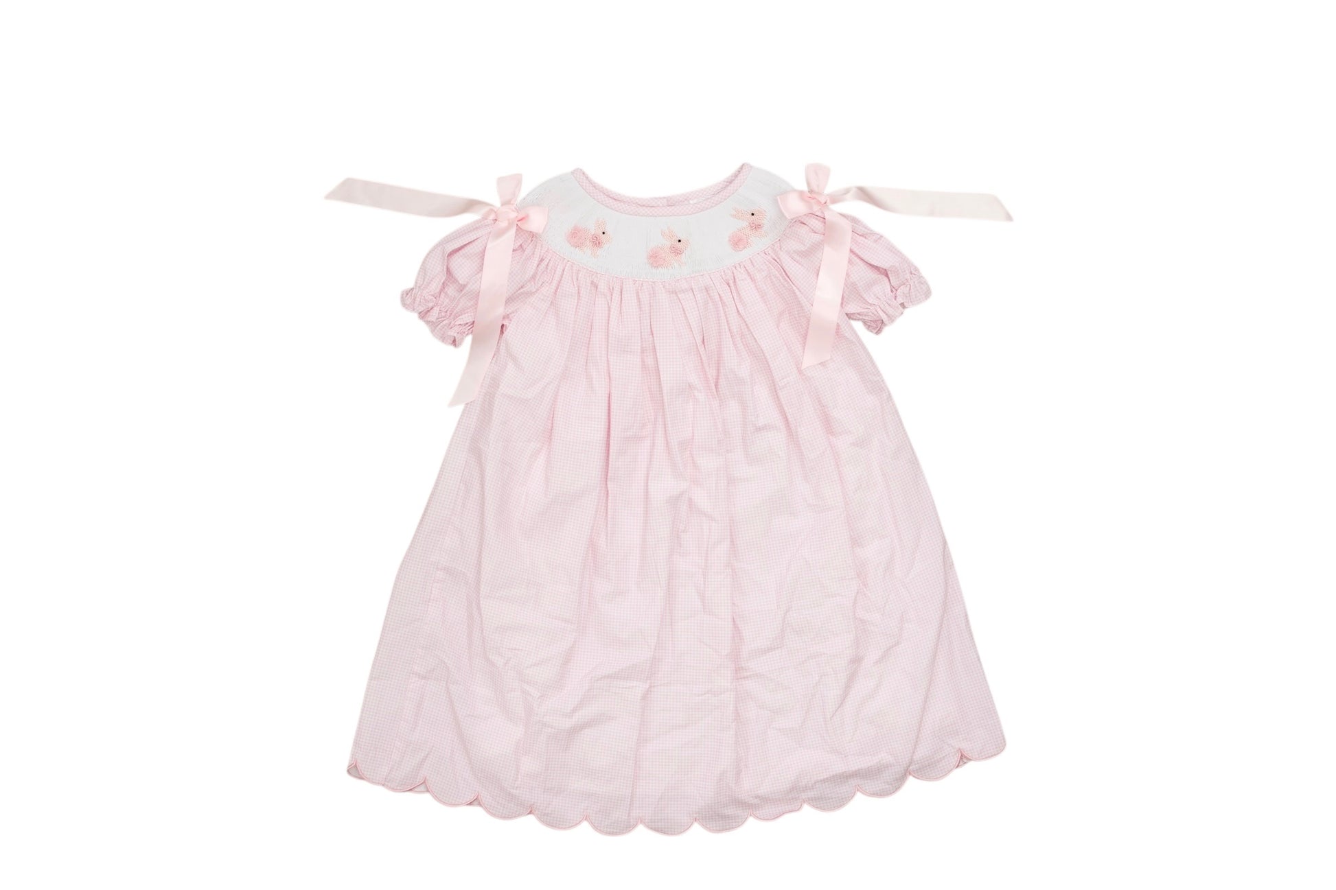 Pink baby dress with ruffles on a white background