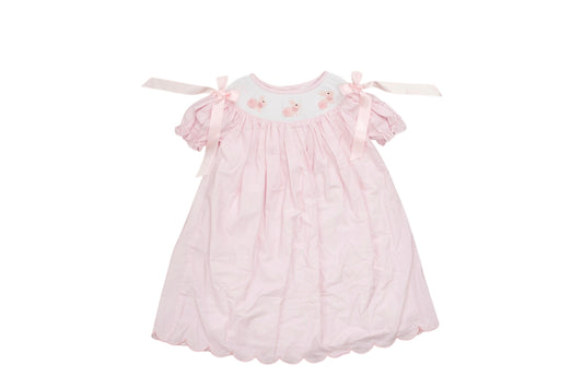 Pink baby dress with ruffles on a white background