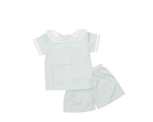 White baby outfit with shirt, shorts, and skirt on a white background