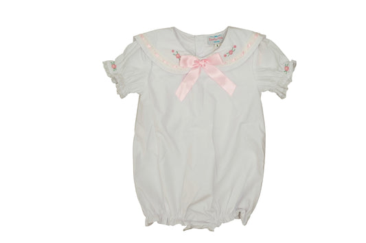 White baby romper with pink bow on a white background