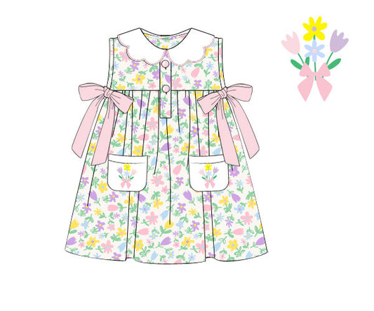 Children's floral dress with pink bows on a white background