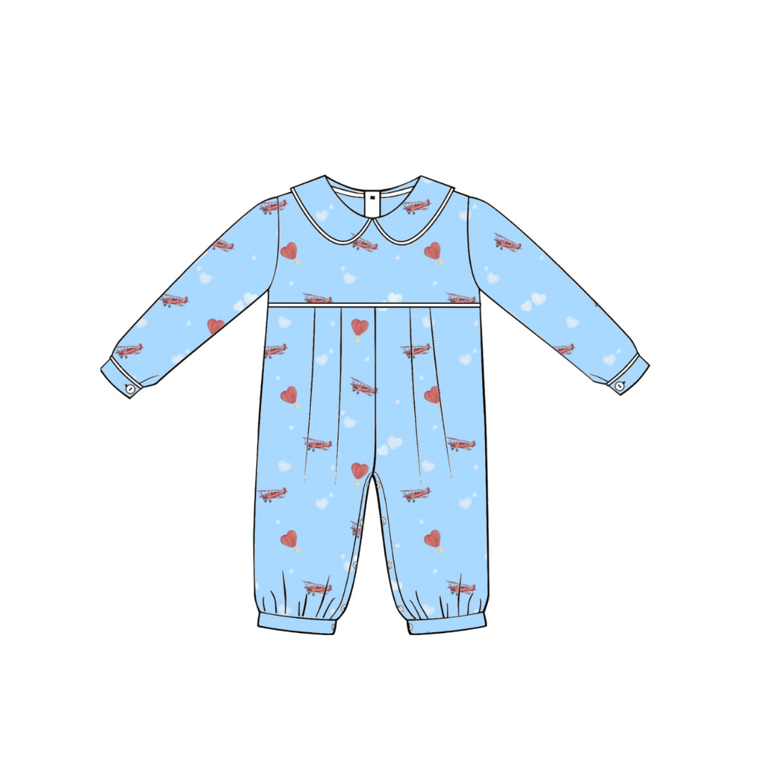 A flat line-art illustration of a baby long-sleeve romper in light blue with a repeating pattern of red hearts, small red butterflies, and white clouds, shown on a plain white background.