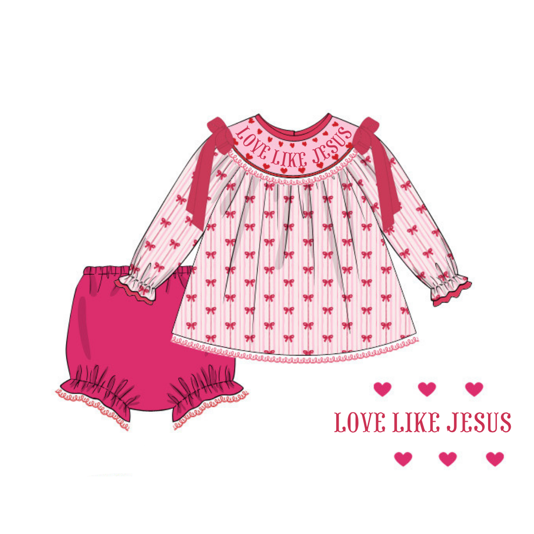 A children's two-piece outfit illustration featuring a long-sleeve top and matching bloomers. The top is white with thin pink vertical stripes, a pink bow at the collar with 'LOVE LIKE JESUS' printed across it, and a repeating small pink heart pattern.